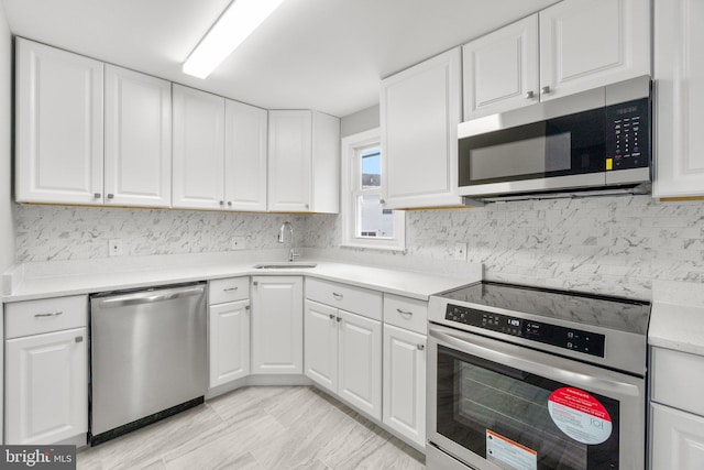 kitchen featuring white cabinetry, stainless steel appliances, sink, and decorative backsplash