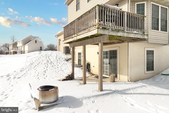 snow covered back of property with a balcony