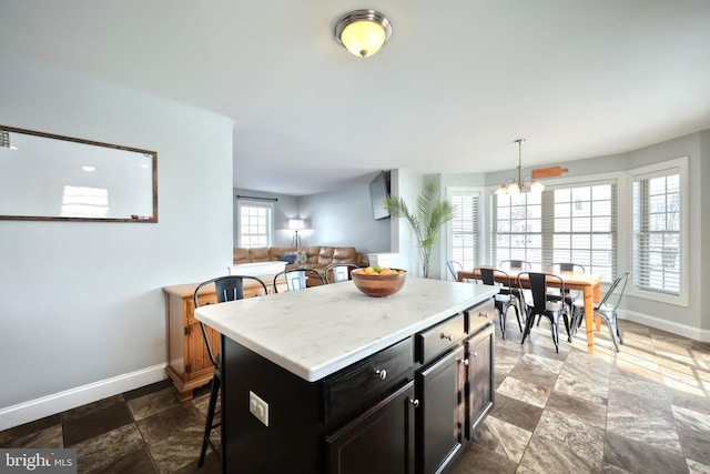 kitchen featuring a kitchen island, a kitchen bar, a chandelier, and decorative light fixtures