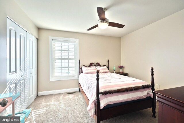 bedroom with a closet, ceiling fan, and light colored carpet