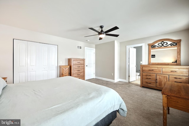 carpeted bedroom featuring a closet, ceiling fan, and ensuite bath