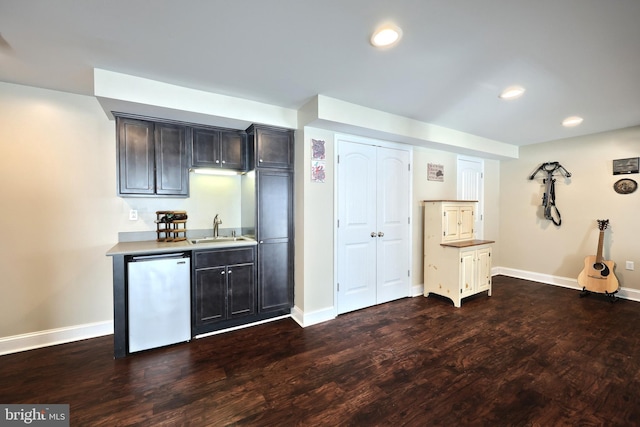 kitchen featuring sink, dishwashing machine, and dark hardwood / wood-style flooring