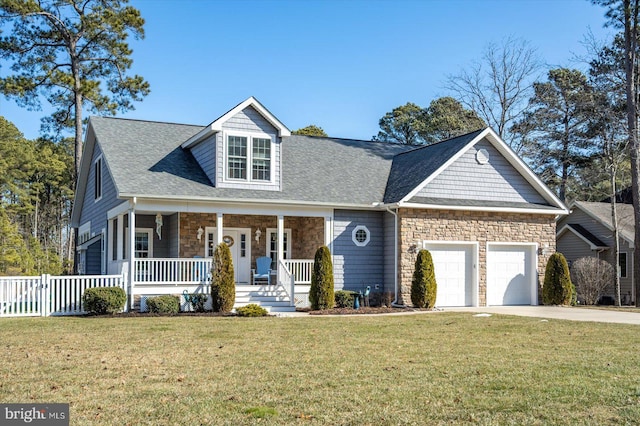 view of front of property with a garage, a front lawn, and a porch