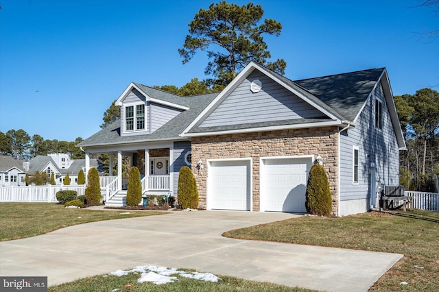 view of front of house featuring a garage, covered porch, and a front yard