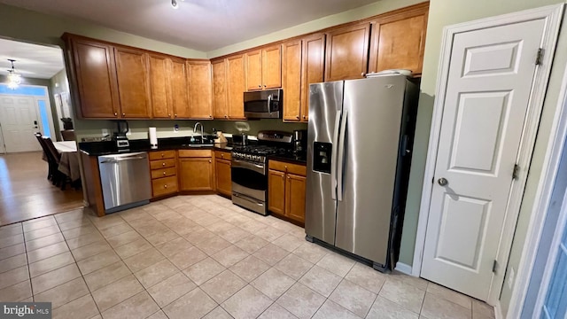 kitchen with sink, appliances with stainless steel finishes, and light tile patterned flooring