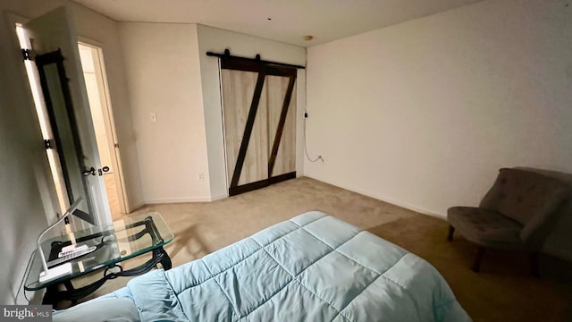 carpeted bedroom featuring a barn door