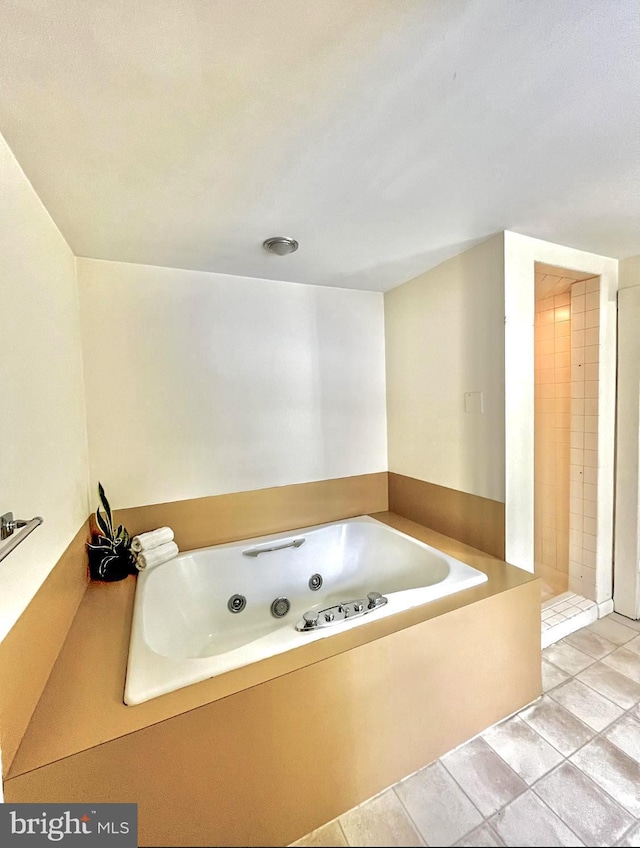 bathroom with a bath and tile patterned flooring