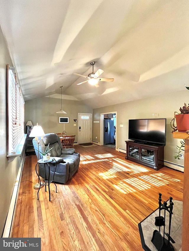 living room featuring a baseboard heating unit, vaulted ceiling, and hardwood / wood-style floors