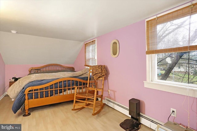 bedroom featuring vaulted ceiling, a baseboard heating unit, and hardwood / wood-style floors