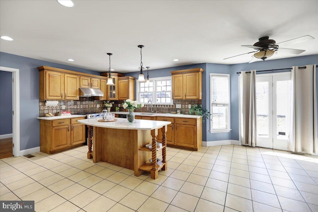 kitchen featuring tasteful backsplash, sink, a center island, and light tile patterned floors