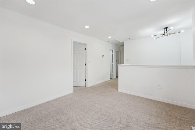 unfurnished room featuring light carpet and a chandelier