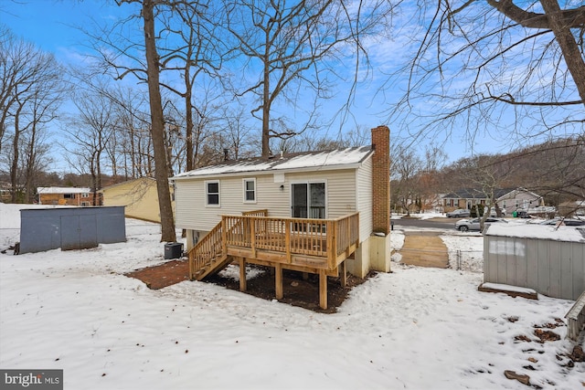 snow covered property featuring a wooden deck and central AC unit