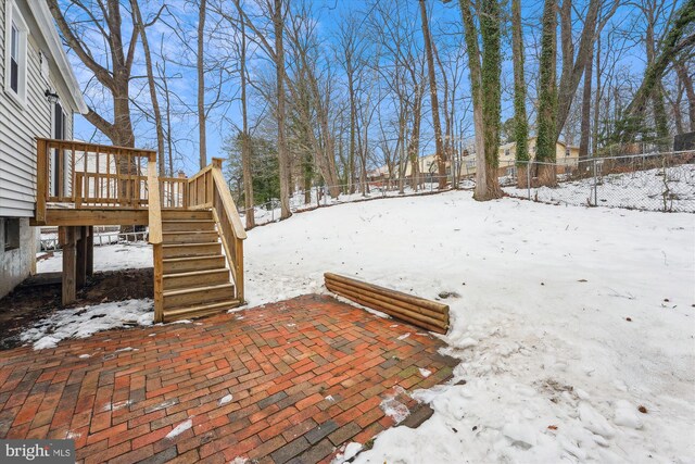 yard layered in snow featuring a deck