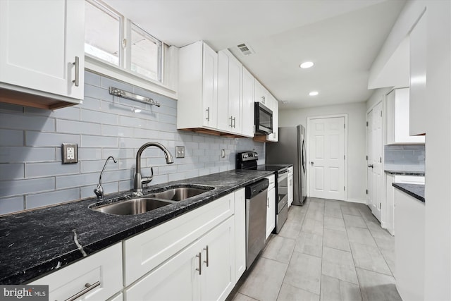 kitchen featuring white cabinetry, sink, stainless steel appliances, and dark stone countertops