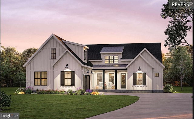 modern inspired farmhouse with covered porch and a lawn