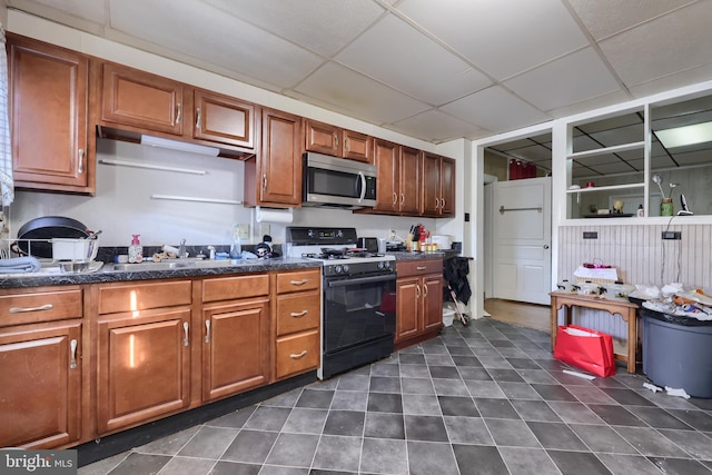 kitchen featuring gas range and a drop ceiling