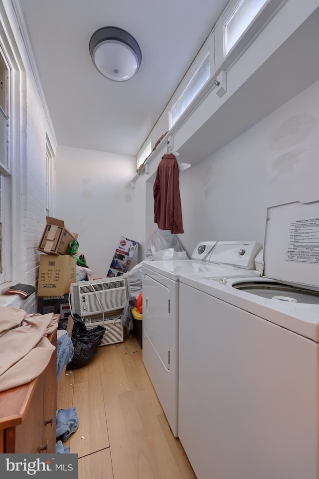 washroom featuring washing machine and clothes dryer and light hardwood / wood-style floors