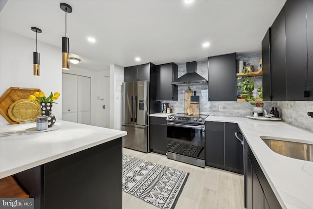 kitchen featuring decorative light fixtures, backsplash, wall chimney range hood, sink, and stainless steel appliances