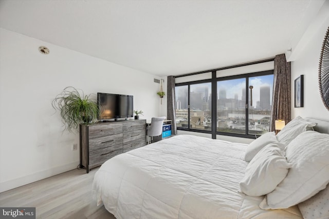 bedroom featuring light hardwood / wood-style floors and expansive windows