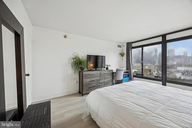 bedroom featuring light hardwood / wood-style floors and expansive windows