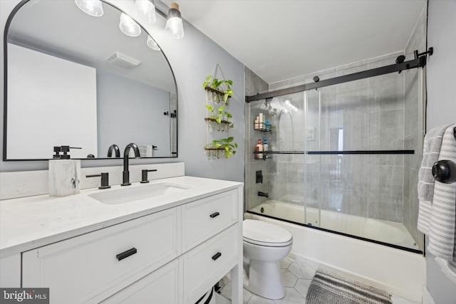 full bathroom featuring combined bath / shower with glass door, vanity, tile patterned flooring, and toilet