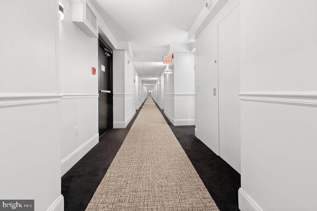 hallway with dark colored carpet