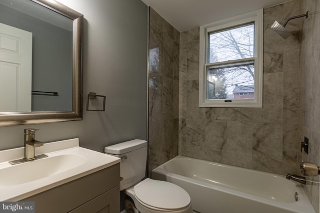 full bathroom featuring tiled shower / bath combo, vanity, and toilet