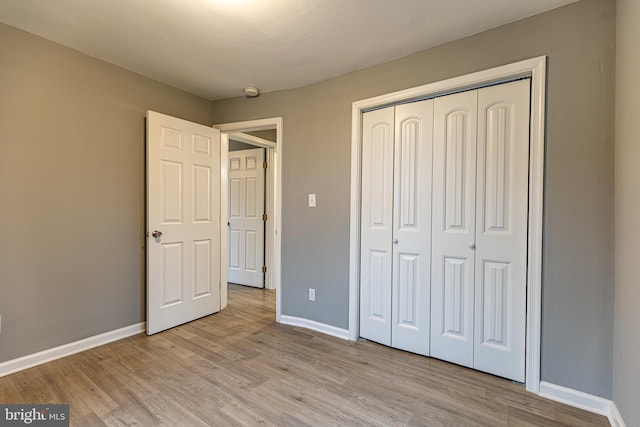 unfurnished bedroom featuring light hardwood / wood-style floors and a closet