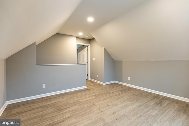 additional living space with lofted ceiling and light hardwood / wood-style floors