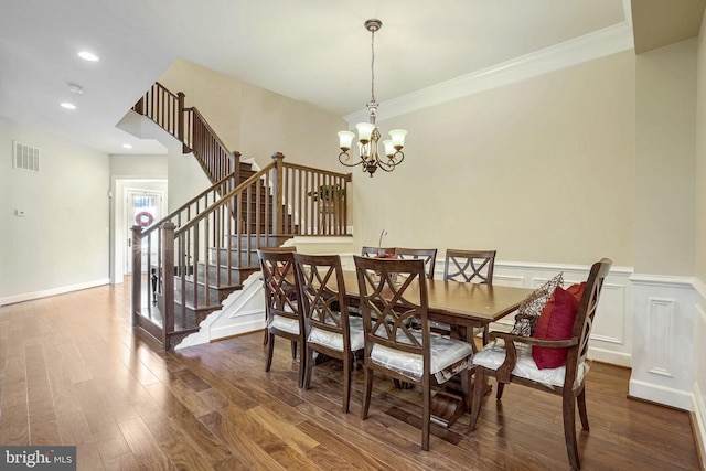 dining room featuring an inviting chandelier, dark hardwood / wood-style flooring, and ornamental molding