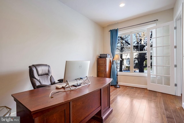 office with a wealth of natural light and light hardwood / wood-style flooring