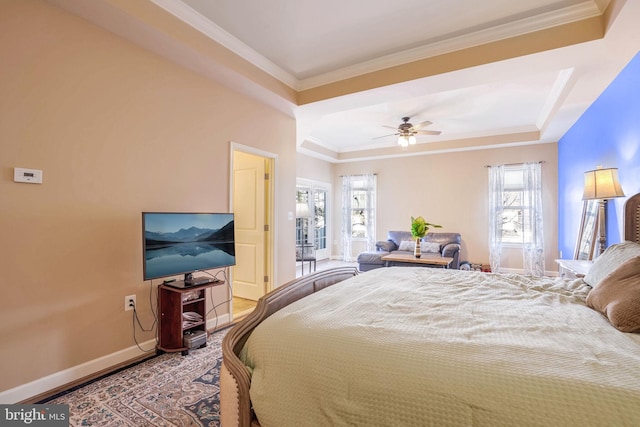 bedroom featuring ceiling fan, wood-type flooring, a tray ceiling, and ornamental molding