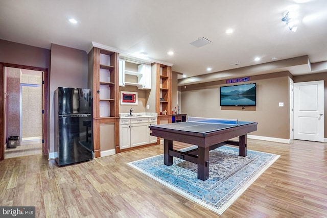 rec room featuring light hardwood / wood-style floors and wet bar