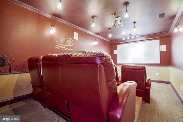 cinema room with track lighting, ornamental molding, and carpet flooring