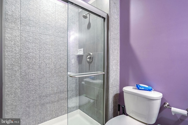 bathroom with toilet and an enclosed shower