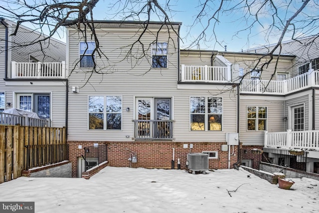 snow covered property with central AC