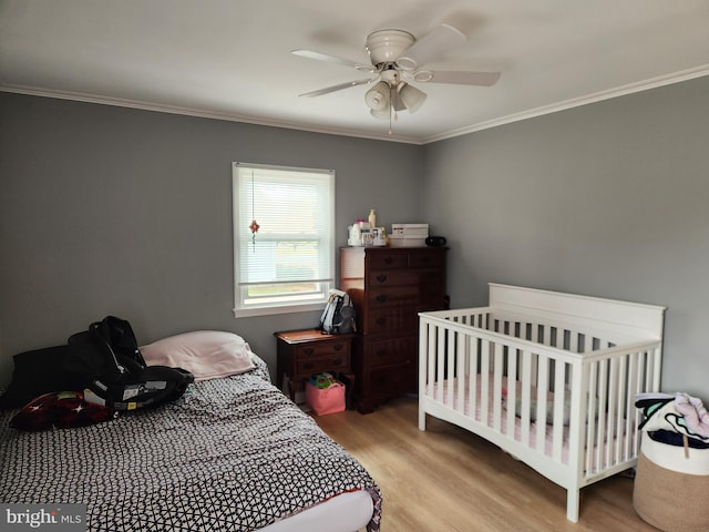 bedroom with ornamental molding, ceiling fan, and light wood-type flooring