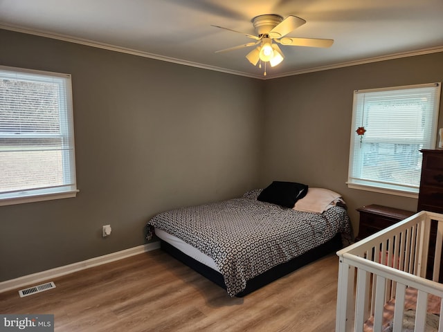 bedroom featuring hardwood / wood-style flooring, ceiling fan, and crown molding