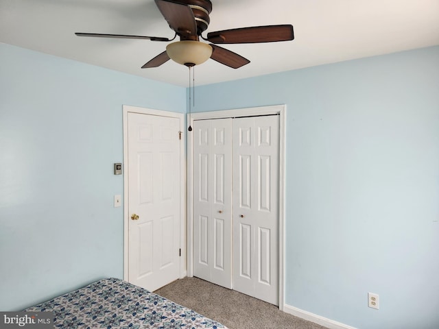 unfurnished bedroom with light carpet, a closet, and ceiling fan