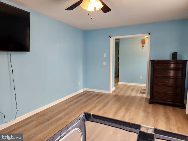 exercise room featuring ceiling fan and light hardwood / wood-style flooring