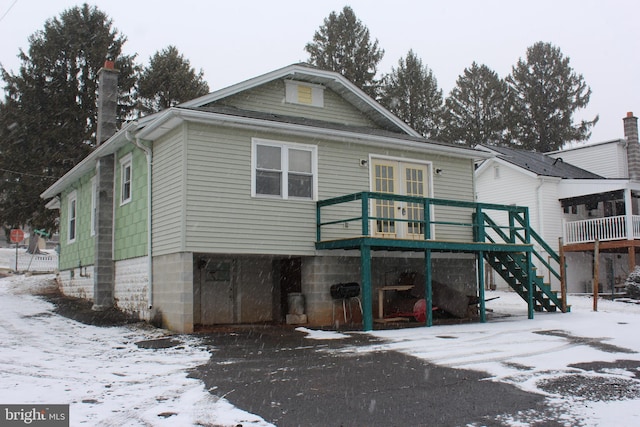 snow covered house featuring a deck