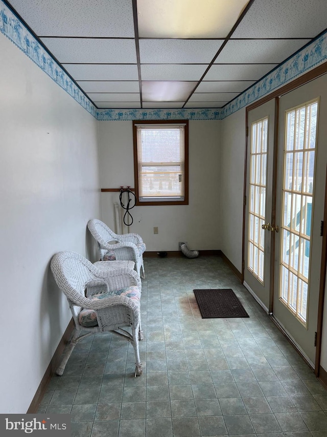 unfurnished room featuring a drop ceiling, tile patterned floors, and french doors