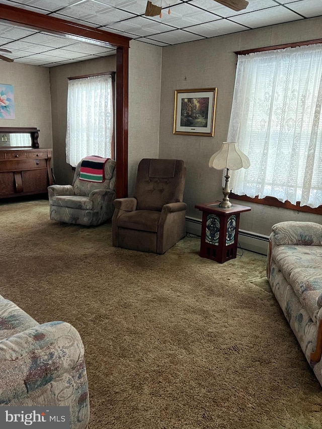 carpeted living room with a baseboard heating unit