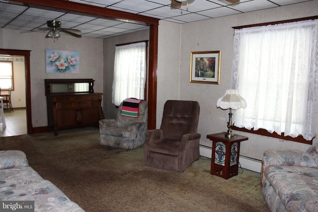 living room featuring a paneled ceiling, ceiling fan, carpet floors, and a baseboard radiator