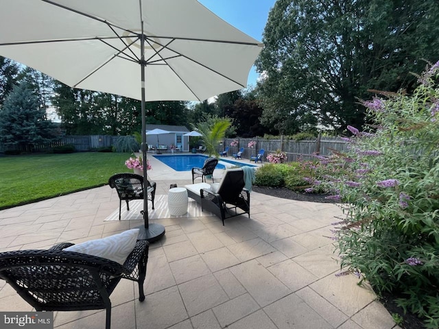 view of patio featuring a fenced in pool and an outbuilding