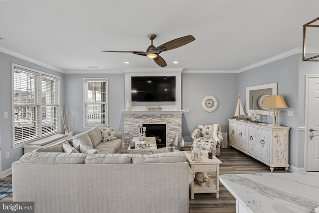 living room with dark wood-type flooring, crown molding, a fireplace, and ceiling fan