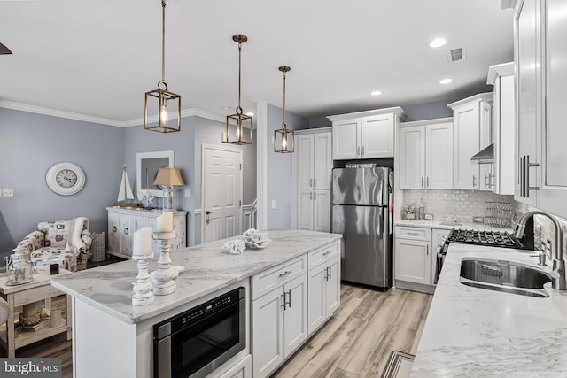 kitchen with stainless steel appliances, pendant lighting, white cabinetry, and sink