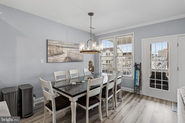 dining space featuring a chandelier, ornamental molding, and hardwood / wood-style floors