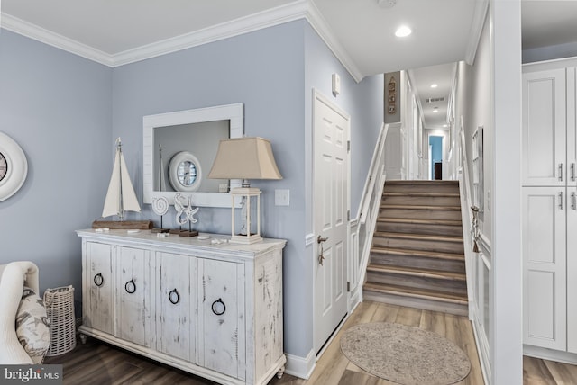 staircase featuring wood-type flooring and ornamental molding