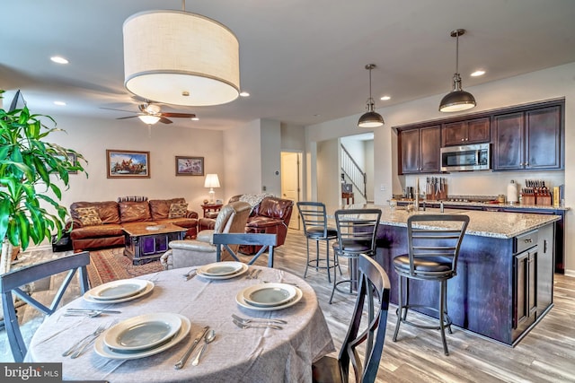 dining area with light hardwood / wood-style floors and ceiling fan